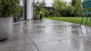 Nasse Feinsteinzeugfliesen auf einer Terrasse