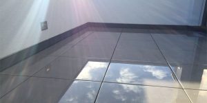 Moderner Balkon mit glänzenden dunklen Fliesen und spiegelnder Oberfläche