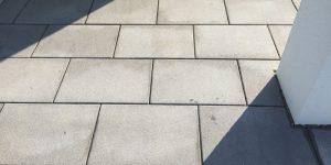 Balkon mit hellgrauen Außenplatten und klarer moderner Linienführung