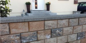 Grenzmauer aus Naturstein mit Abdeckplatten vor Hauseingang – Referenz bei Herrenberg