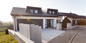 Einfahrt mit modernem Pflaster und massiven Granitstelen im Vorgartenbereich