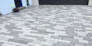 Moderne Einfahrt mit großformatigem grauem Pflaster vor Garage – Referenz bei Sindelfingen