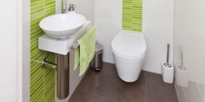 Badezimmer mit grünen Fliesen und individueller Wandgestaltung