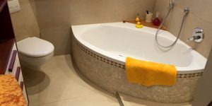 Bad mit Natursteinoptik rund um die Badewanne und hochwertiger Wandgestaltung