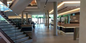 Moderner Empfangs- und Trainingsbereich in einem Fitnessstudio mit großformatigen Bodenfliesen