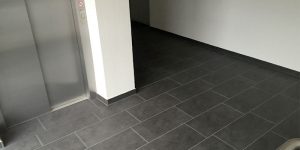 Gewerbeflur mit Aufzug und anthrazitfarbenen Bodenfliesen – Referenz im Raum Böblingen