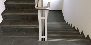 Modernes Treppenhaus mit dunklen großformatigen Bodenfliesen im Gewerbebereich